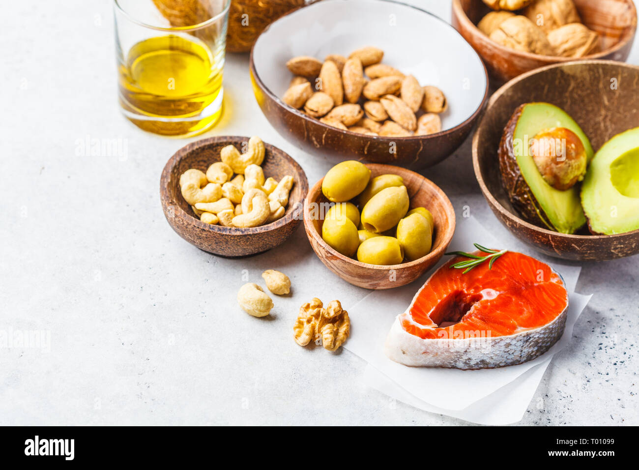 Selection of healthy fat sources: fish, nuts, oil, olives, avocado on white background, copy space Stock Photo