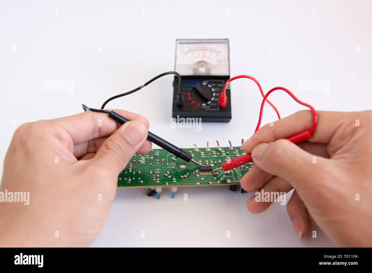 Technician hand with multimeter probes repairing circuit board Stock ...