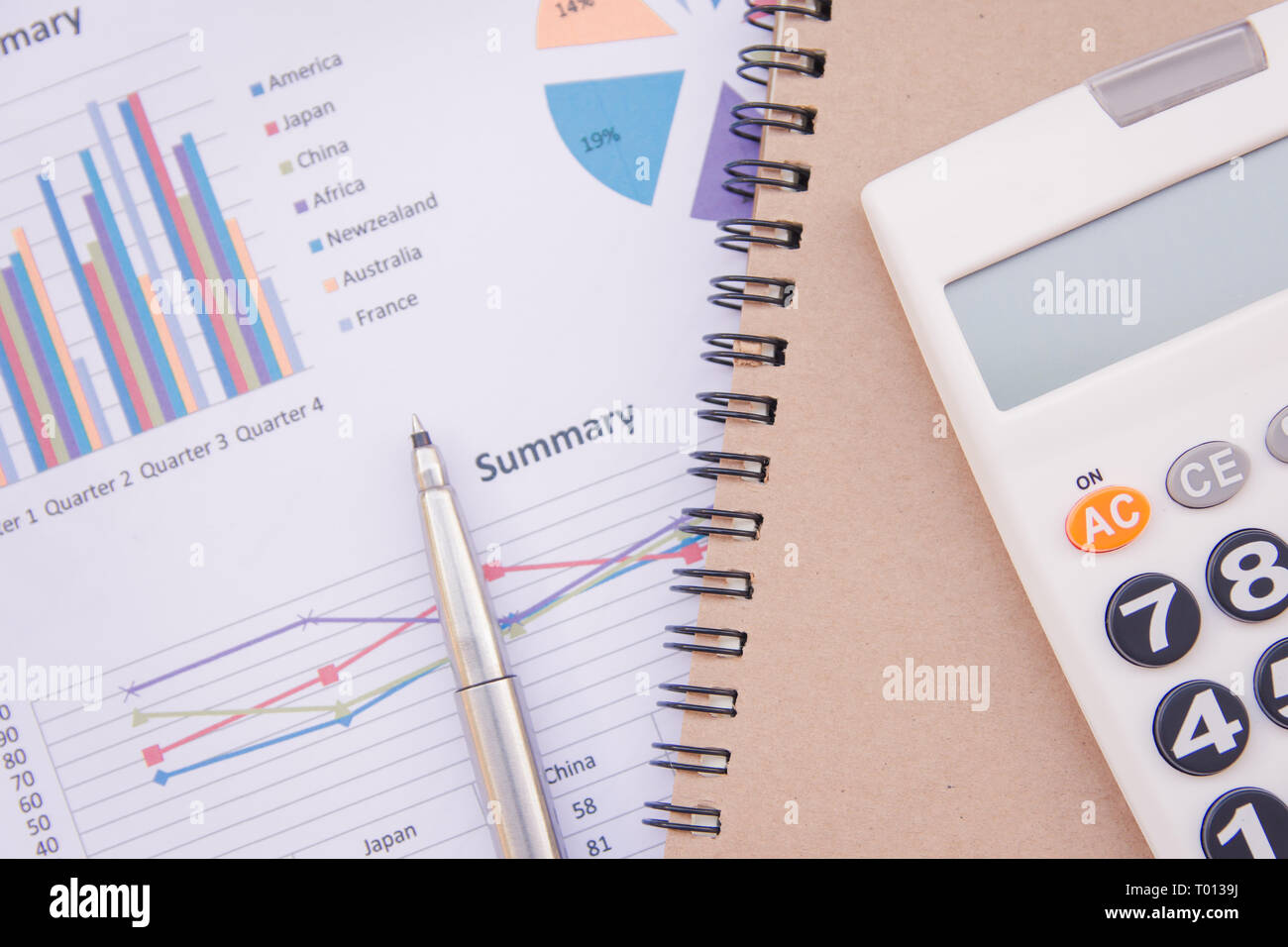data analyzing with calculator, notebook and pen. on charts and graph ...