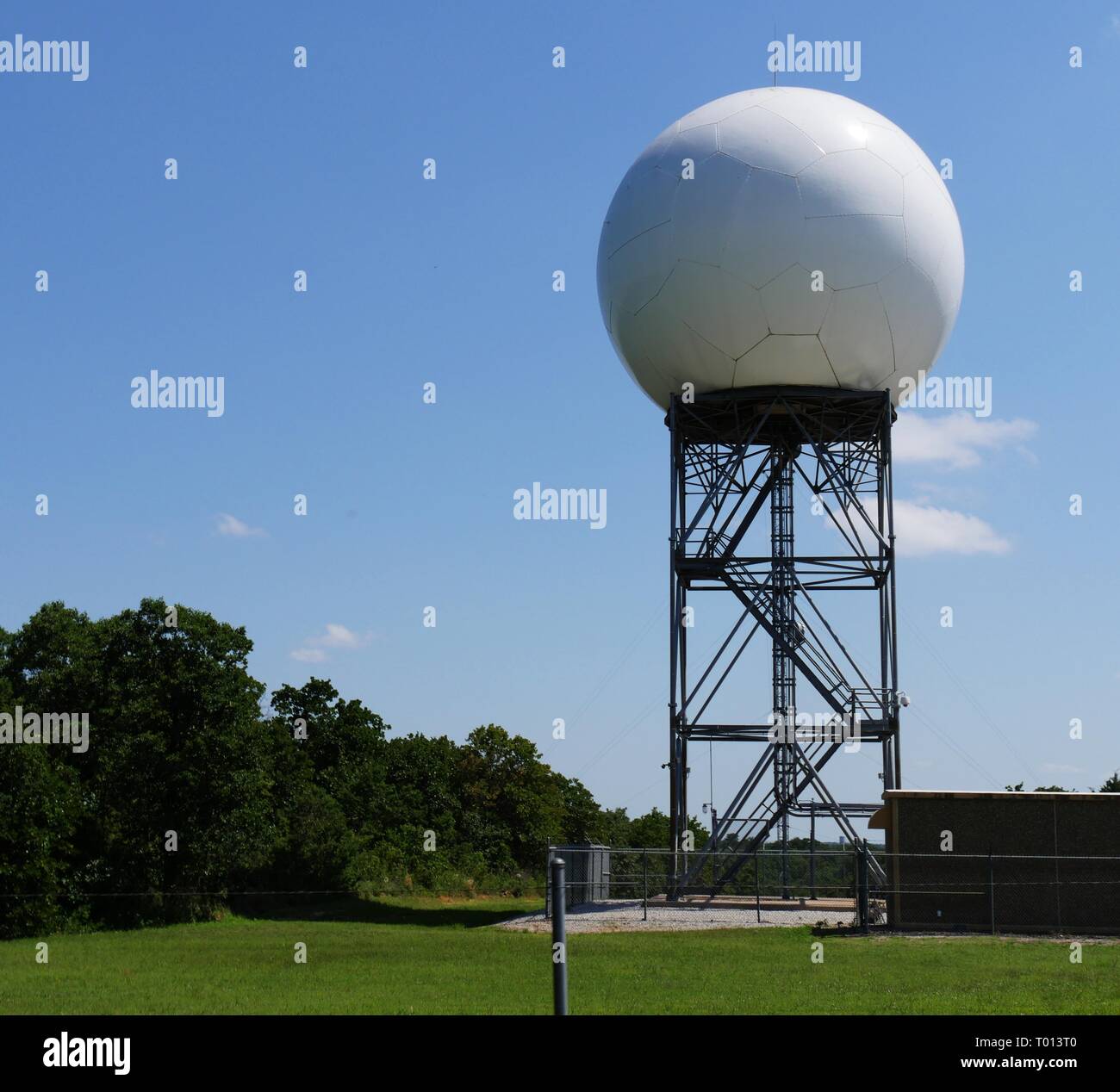 A huge white Doppler weather radar sitting on top of a steel structure