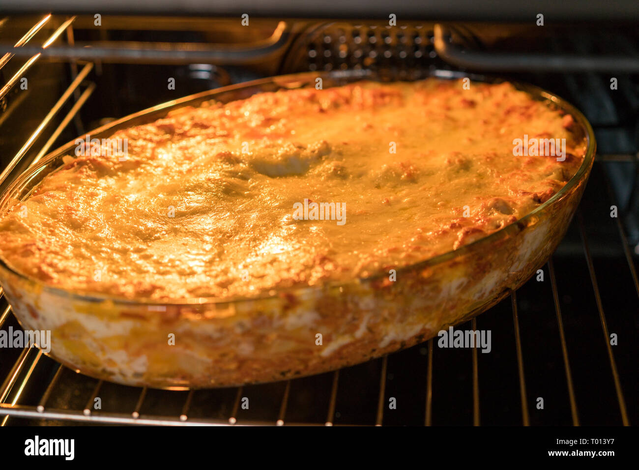 Dish Of Lasagne Cooking Inside Oven. Baking tray with spinach lasagna