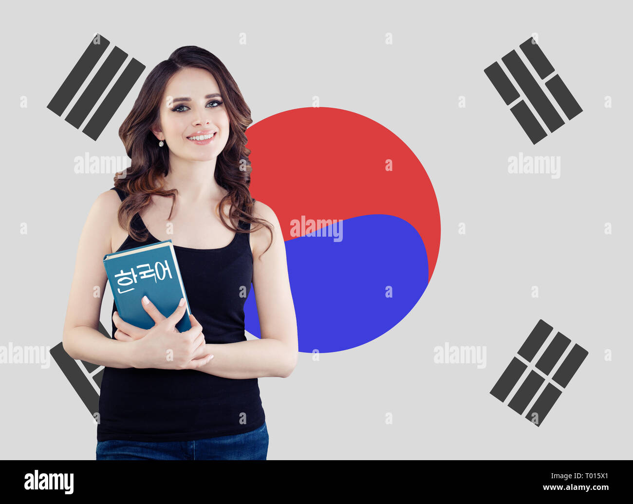 Learn korean language. Pretty young woman student with book against the South Korea flag background Stock Photo