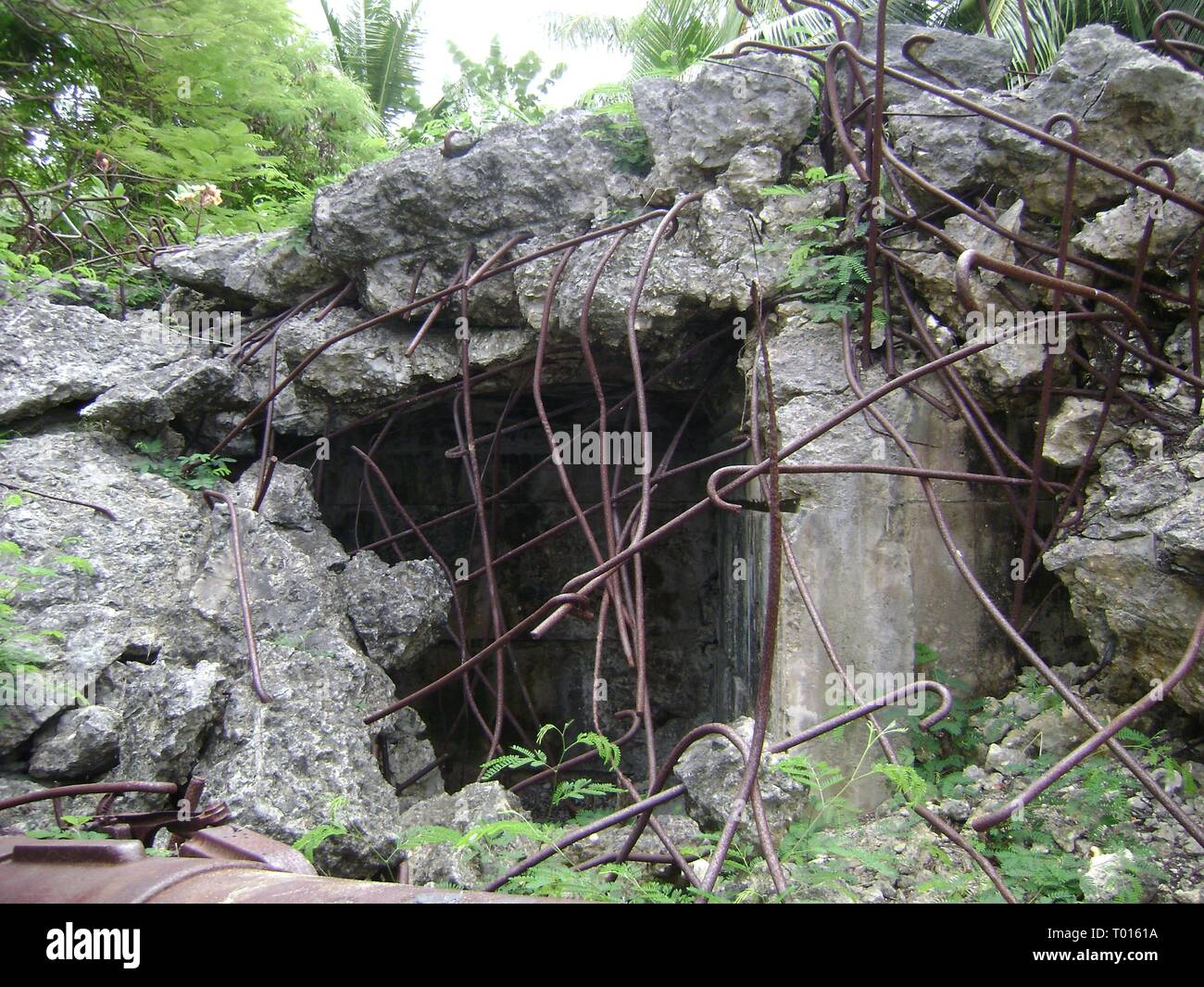 Relics of a World War 11 Japanese pillbox with rusty steel posts sticking out at Managaha Island in Saipan Stock Photo
