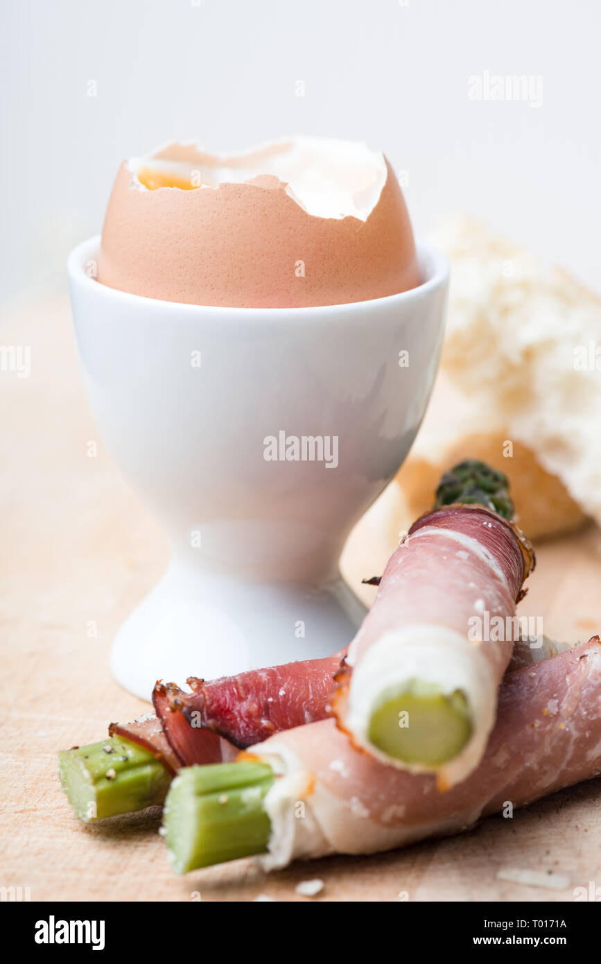 breakfast with soft boiled egg and asparagus wrapped in Parma ham Stock