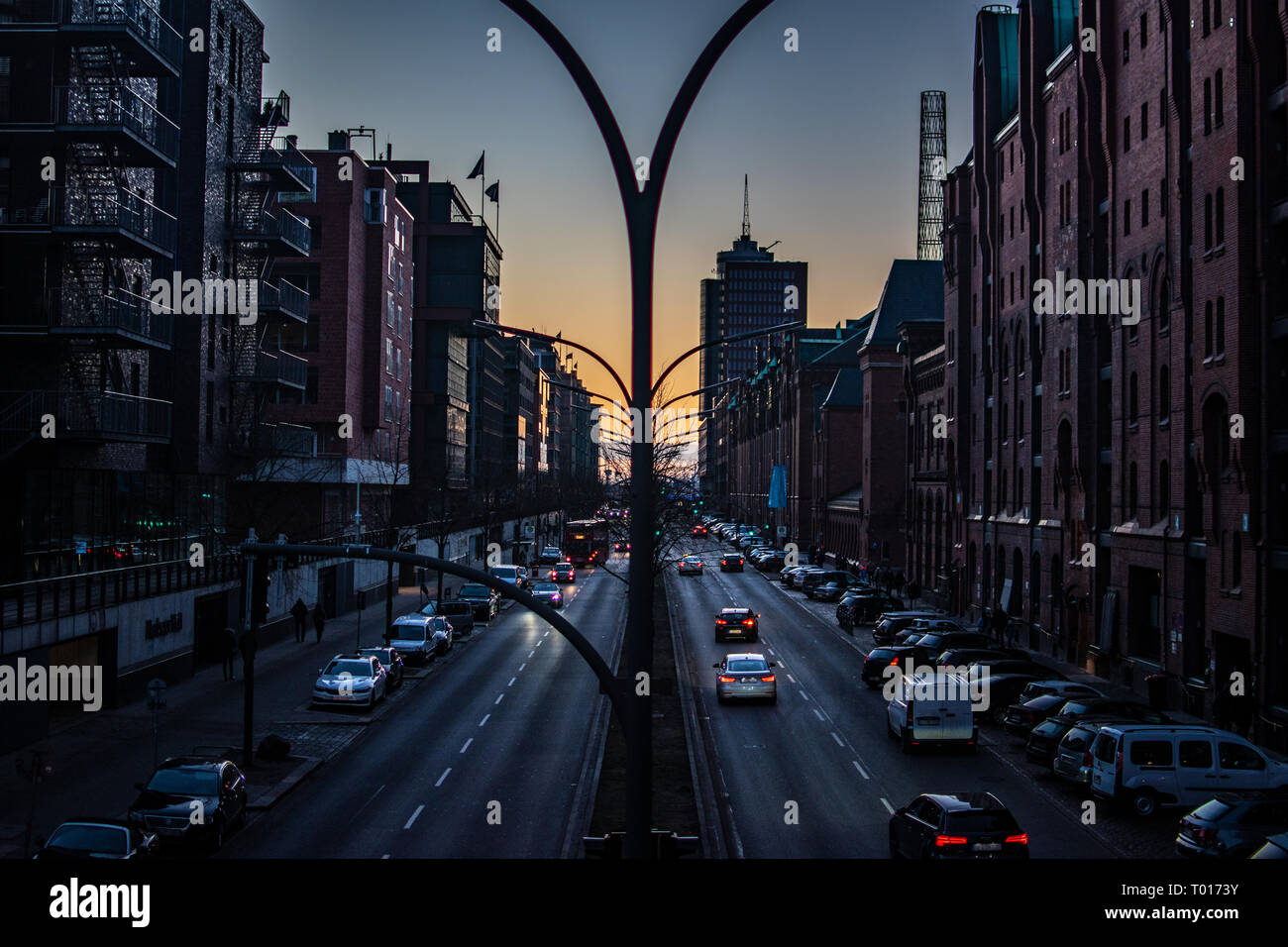The view of the beautiful sunset on the road with cars in the city. A beautiful warm light. Traffic jam. Free, empty place Stock Photo