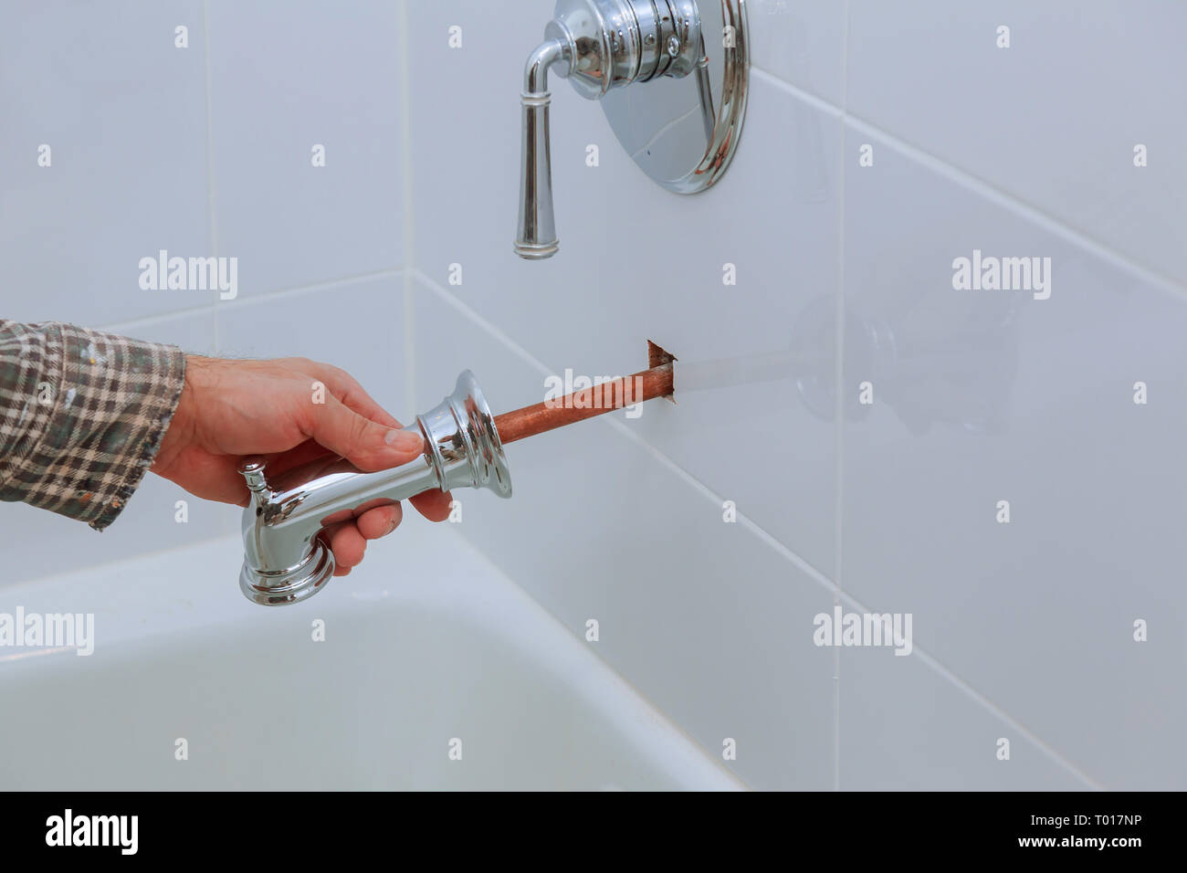 Plumber installing water faucet in the bathroom with thermostat Stock Photo