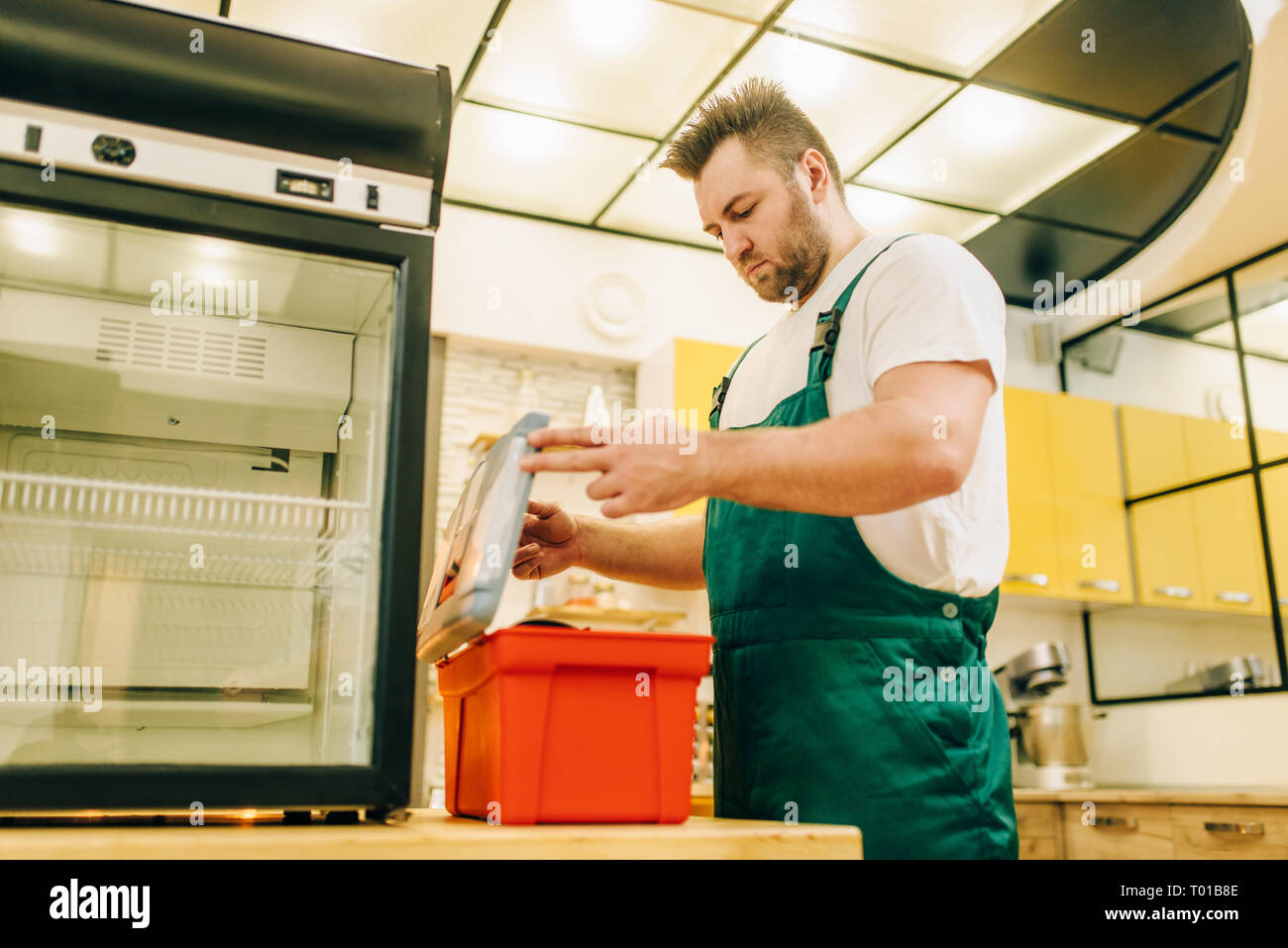 Worker with toolbox repair refrigerator at home Stock Photo Alamy