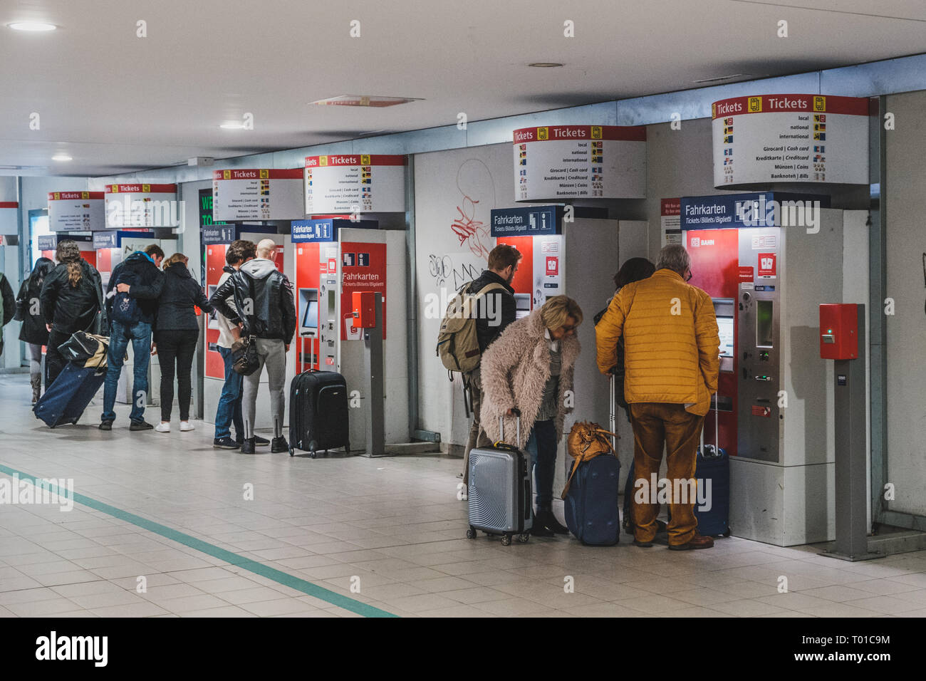 Berlin, Germany - march 2019: People with luggage buying train ticket at vending machine near airport in Berlin Stock Photo