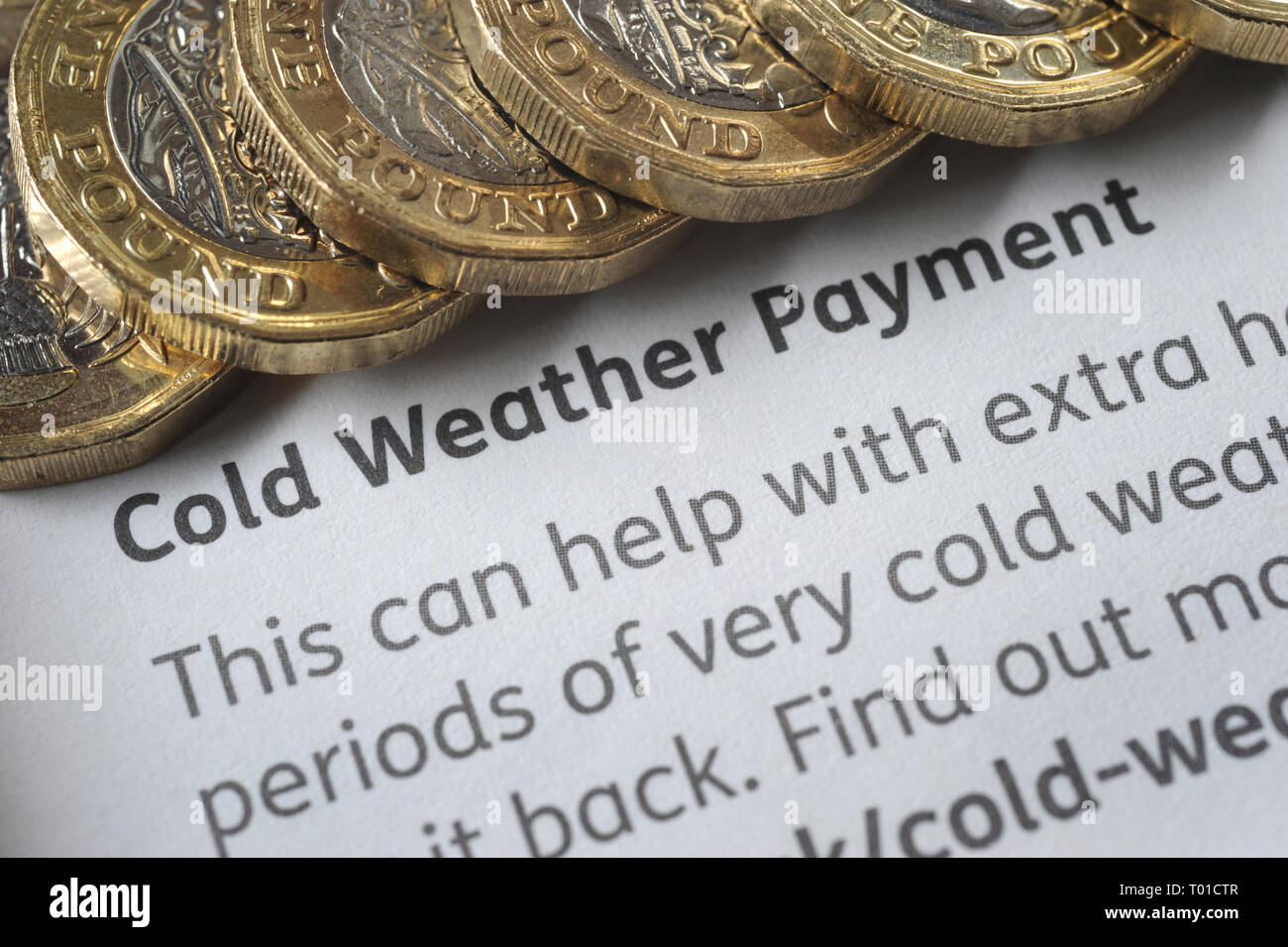 DWP COLD WEATHER PAYMENT LEAFLET WITH ONE POUND COINS RE BENEFITS THE ELDERLY PENSIONERS LOW INCOME PENSION CREDIT ETC UK Stock Photo