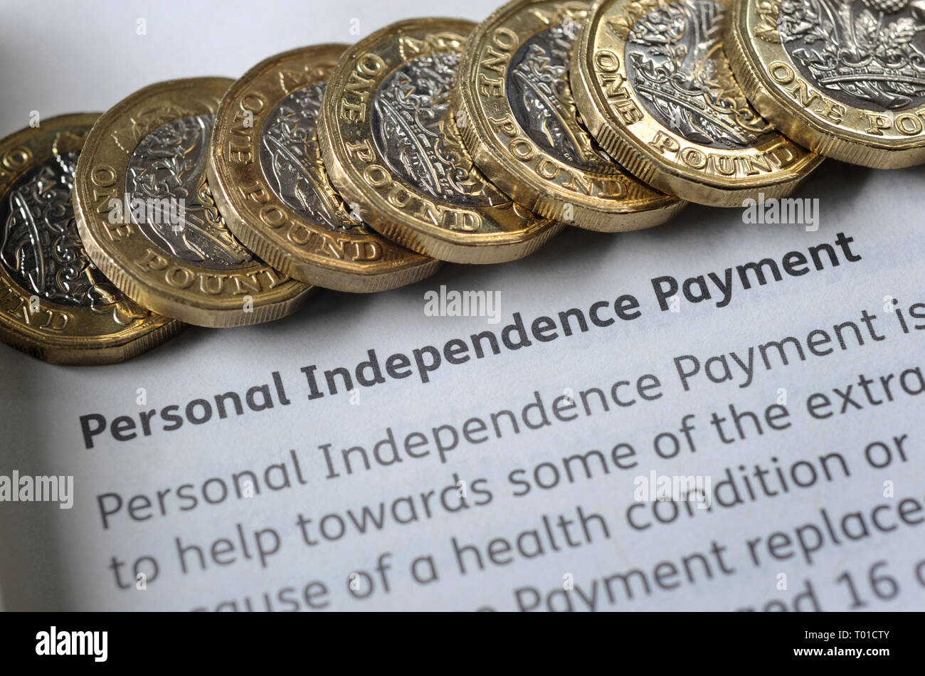 DWP PERSONAL INDEPENDENCE PAYMENT LEAFLET WITH ONE POUND COINS RE BENEFITS THE ELDERLY PENSIONERS LOW INCOME DISABILITY PENSION CREDIT ETC UK Stock Photo