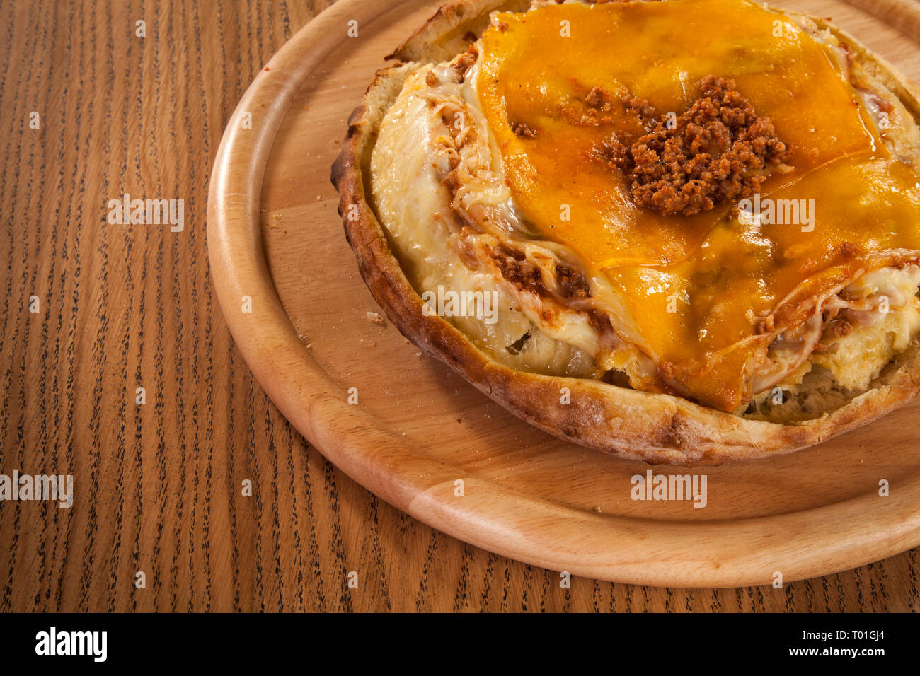 Pasta with minced beef meat and cedar cheese served on roasted bread crust Stock Photo