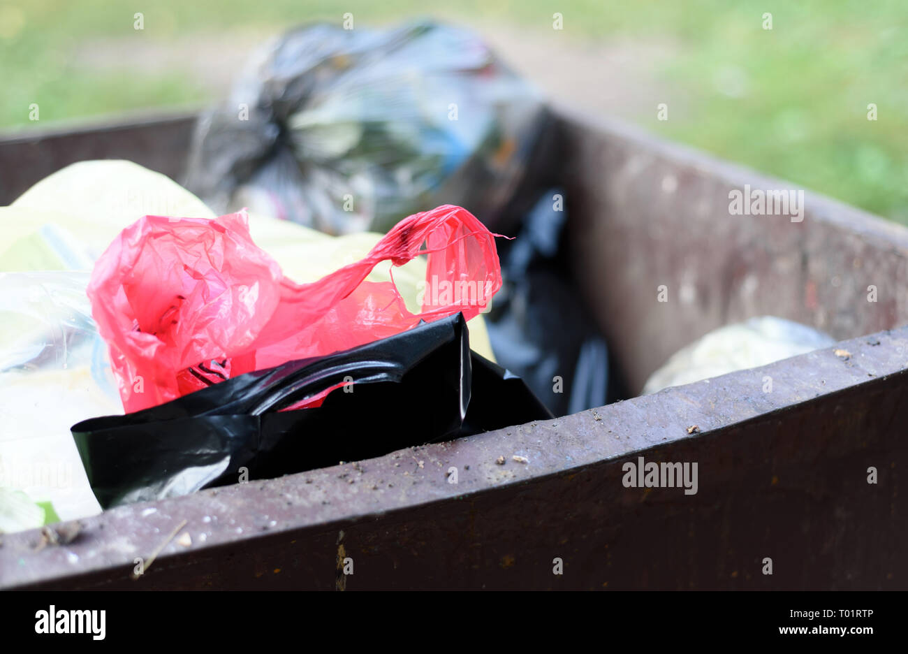 Plastic rubbish bags in a metal refuse bin awaiting collection as part of household waste Stock Photo