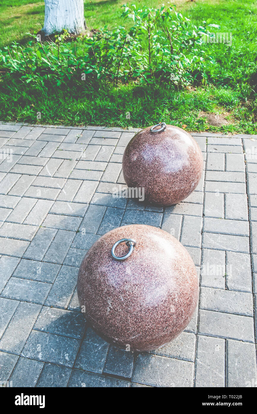 Stone balls on a city street. City square design. The ruler is a large  outdoor decorative glacier from natural granite spheres. Metal hooks on the  bal Stock Photo - Alamy