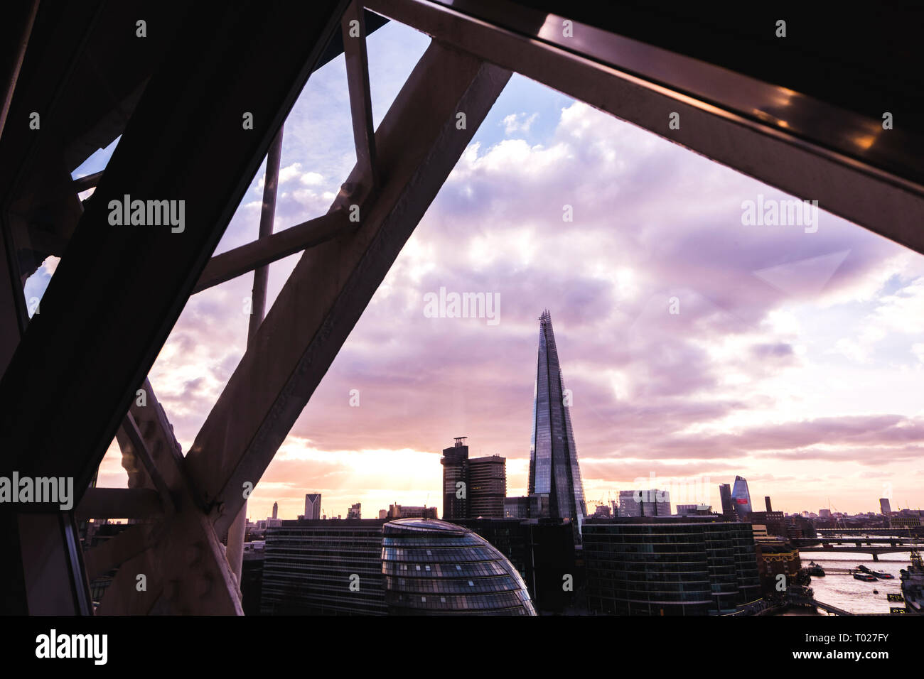 Panoramic view of London skyline. Cityscape with the Shard and the City hall building in sunset light, seen from inside the Tower bridge. Stock Photo