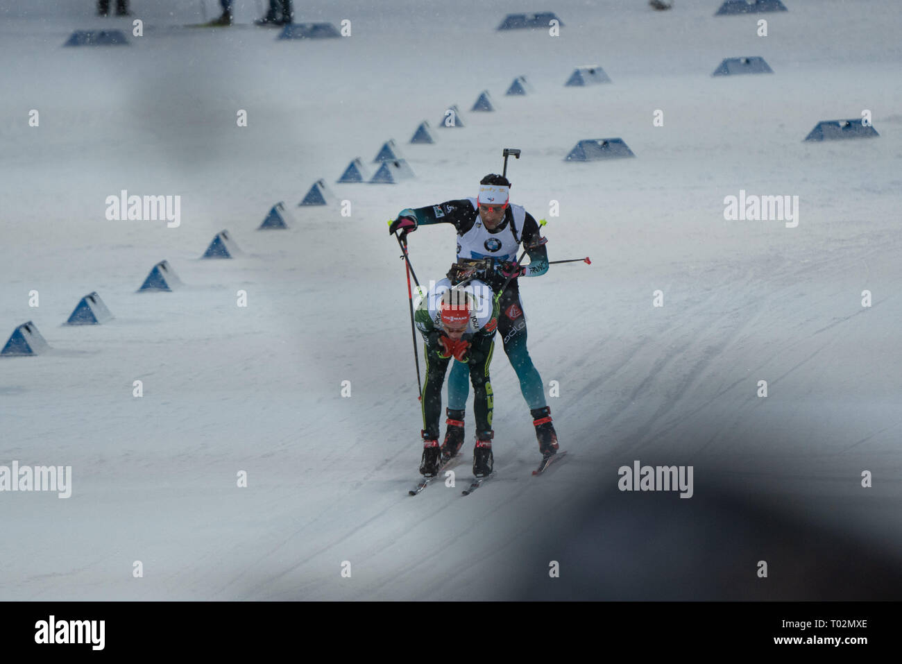Ski Stadium, Oestersund, Sweden, 17th March 2019 It was Men's and Women's Relays day at the IBU Biathlon World Championships and 20,000 fans filled the stadium in Östersund. Pictured: Martin Fourcade of France holds the poles of Benedikt Doll of Germanty during the final leg. Picture: Rob Watkins/Alamy News Stock Photo