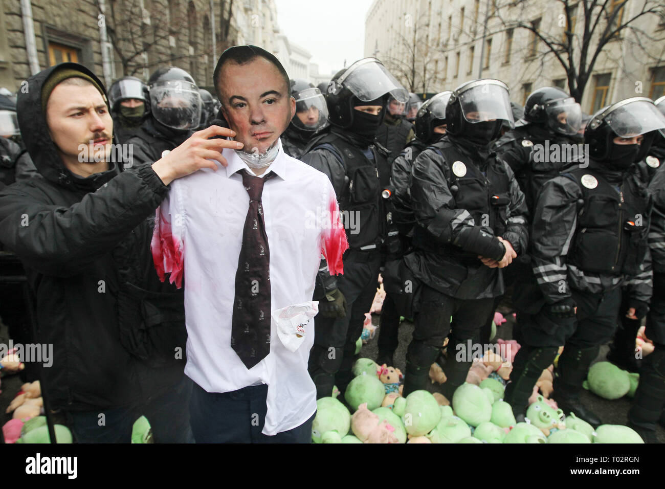 Kiev, Ukraine. 16th March 2019. An activist of the Ukrainian far-right party National Corps seen holding a scarecrow without hands depicting the First Deputy Secretary of the National Security and Defence Council of Ukraine Oleg Gladkovsky, in front of riot policemen guarding the Ukrainian President's office during the protest. Protest against corruption in the country's defence industry in Kiev, Ukraine. Credit: SOPA Images Limited/Alamy Live News Stock Photo