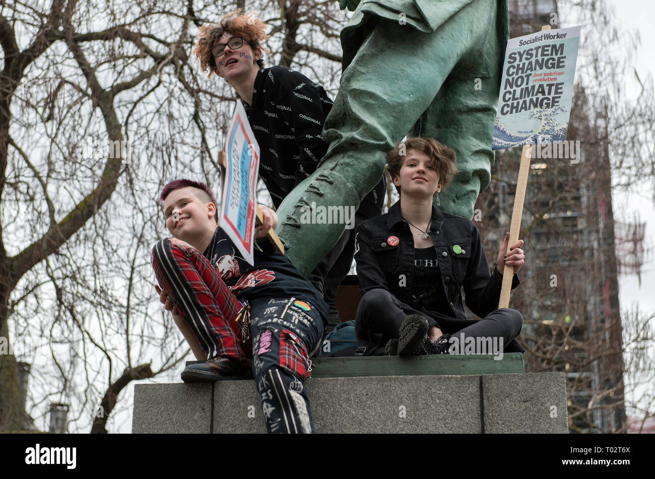 Youths are seen seen with placards next to a sculpture at Parliament Square during the protest. Hundreds of young people gathered at Parliament Square, joining the Global Climate Strike and demanding from the government and politicians direct actions to tackle the climate change. Students in more than 100 countries went to the streets to participate in a climate global strike. Stock Photo