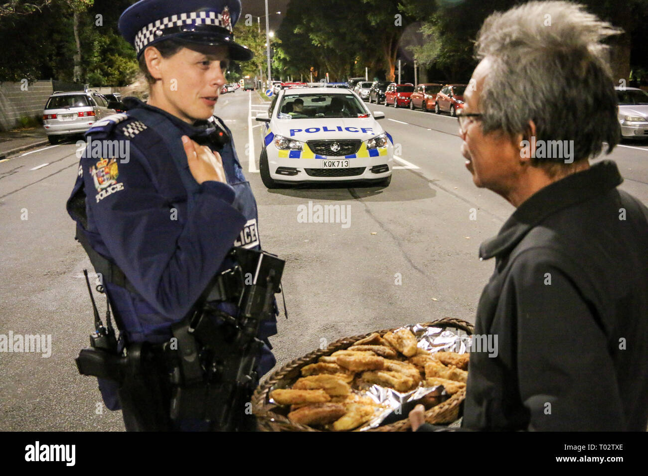 Christchurch, New Zealand. 16th March 2019. Police officer on a long guard shift is offered some comfort food by a member of the Indonesian community after the Christchurch mosques shooting. Around 50 people has been reportedly killed in the Christchurch mosques terrorist attack shooting targeting the Masjid Al Noor Mosque and the Linwood Mosque. Credit: SOPA Images Limited/Alamy Live News Stock Photo