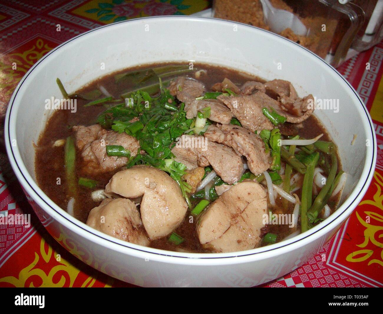 Chicken and pork stew with kangkung leaves in savory sauce served in a
