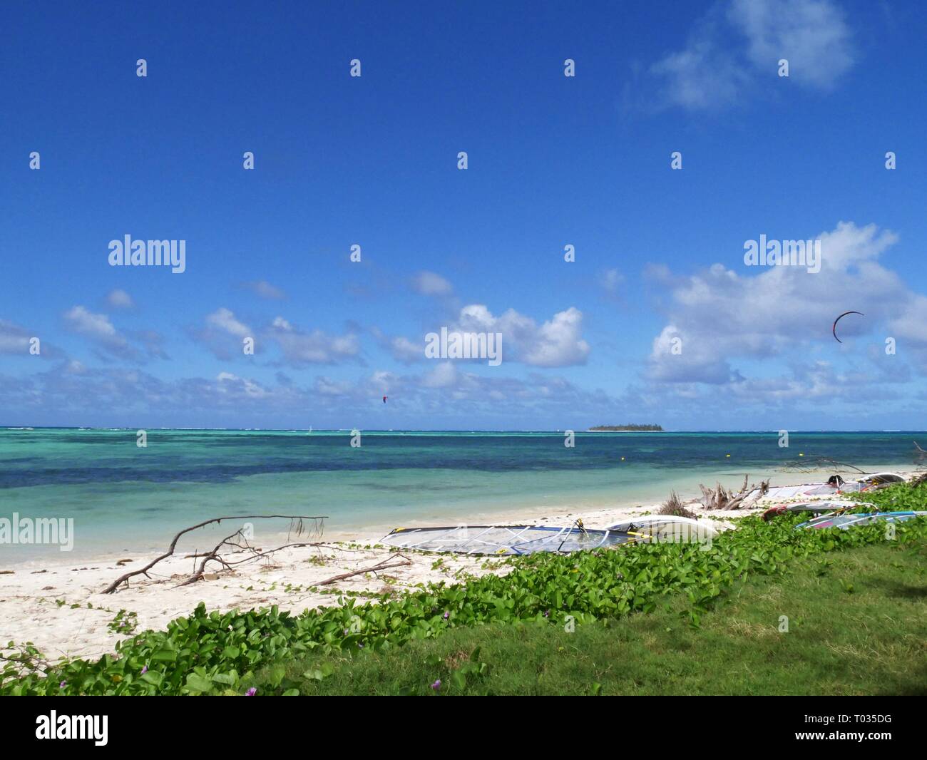 Micro Beach on Saipan, with debris all over the beach after a storm. Seen in the distance is Managaha Island Stock Photo