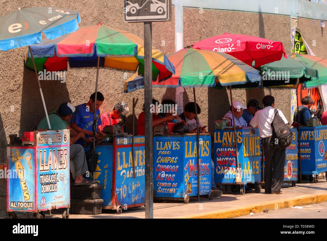 Chimbote, Peru - April 18, 2018: Key cutting stalls under brightly coloured umbrellas Stock Photo