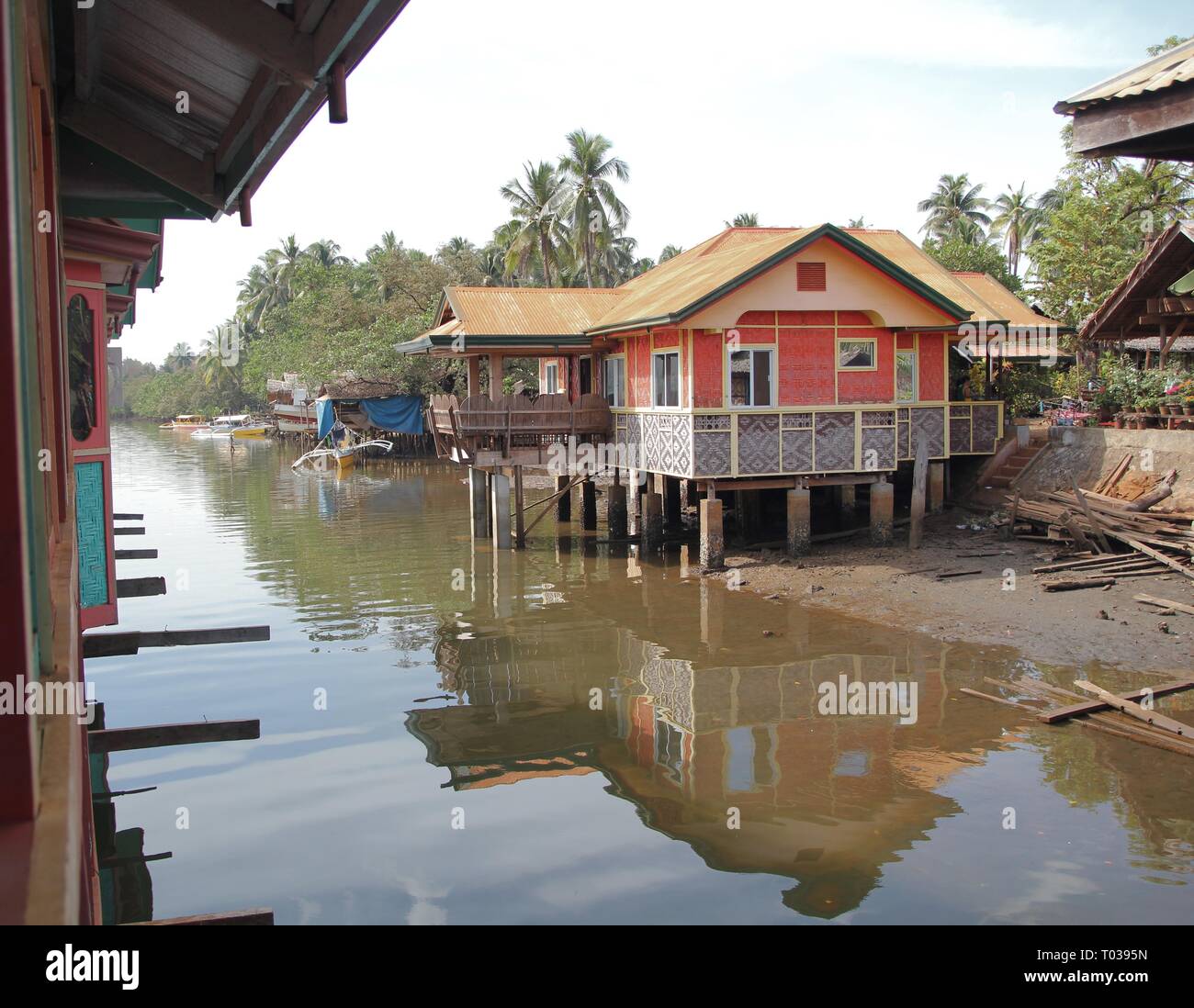 SURIGAO DEL SUR, PHILIPPINES—AUGUST 2014: Houses by the riverside in posts to protect them from rising water in Surigao del Sur Stock Photo