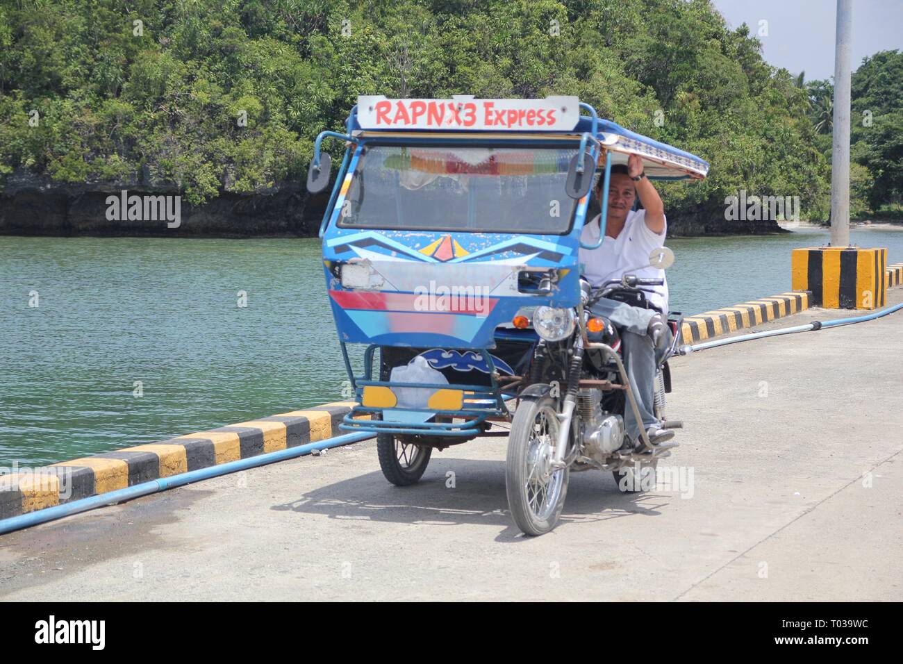 SURIGAO DEL SUR, PHILIPPINES—A tricycle driver smiles for the camera at Cantilan, Surigao del Sur, southern Philippines in August 2014. Stock Photo