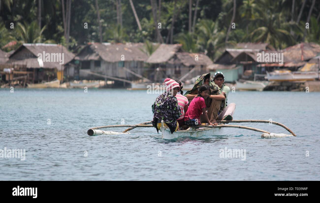 SURIGAO DEL SUR, PHILIPPINES—AUGUST 2014: A boatload of passengers head toward a fishing village in Libtong Cove, Cantilan, Surigao del Sur. Stock Photo