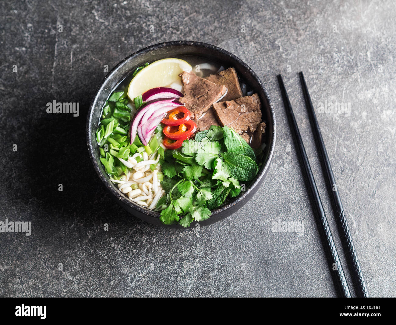 Pho Bo soupe vietnamienne à base de boeuf dans le bac en bois sur fond de  bois Photo Stock - Alamy