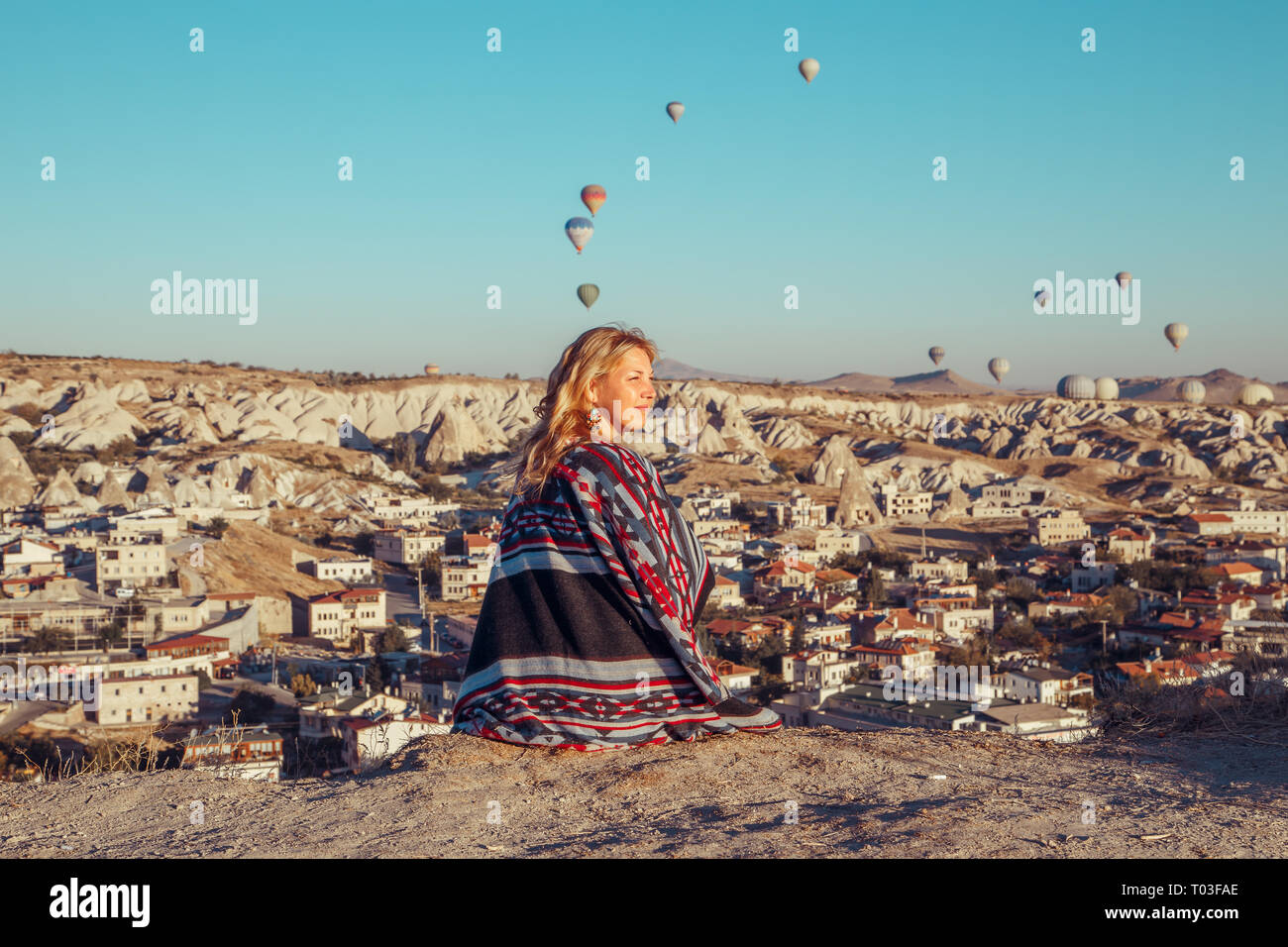 Girl at dawn watching the balloons and enjoying life. Cappadocia, Goreme, Turkey - September 24, 2018. Stock Photo