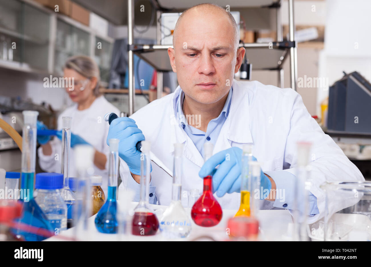 Experienced chemist working in research laboratory, analyzing liquid samples Stock Photo