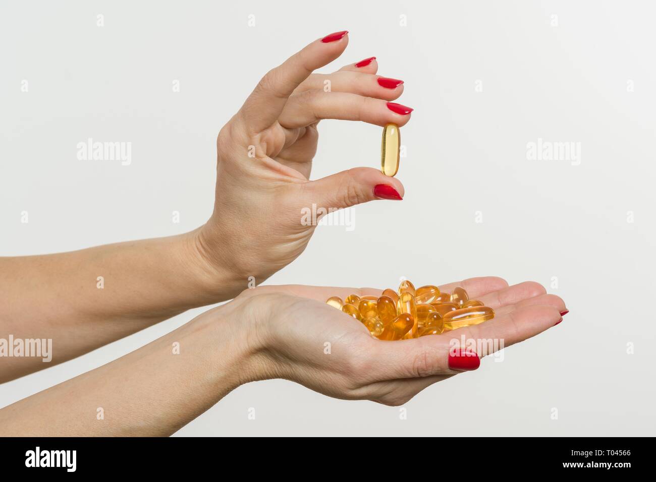 Hand holding capsule of Omega 3 on white background Stock Photo