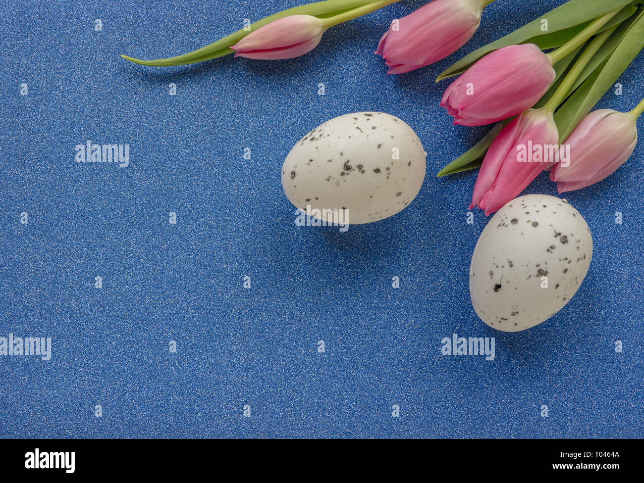 Easter background with pink tulips and egg on blue glitter background ...