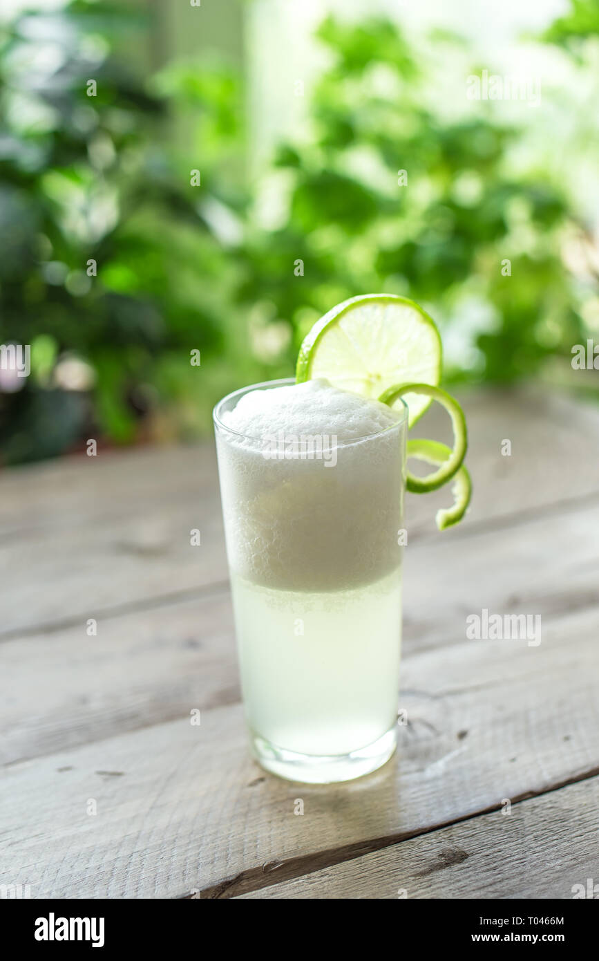 Egg Gin Fizz Cocktail with Lime Garnish. Making Gin Fizz Drink with