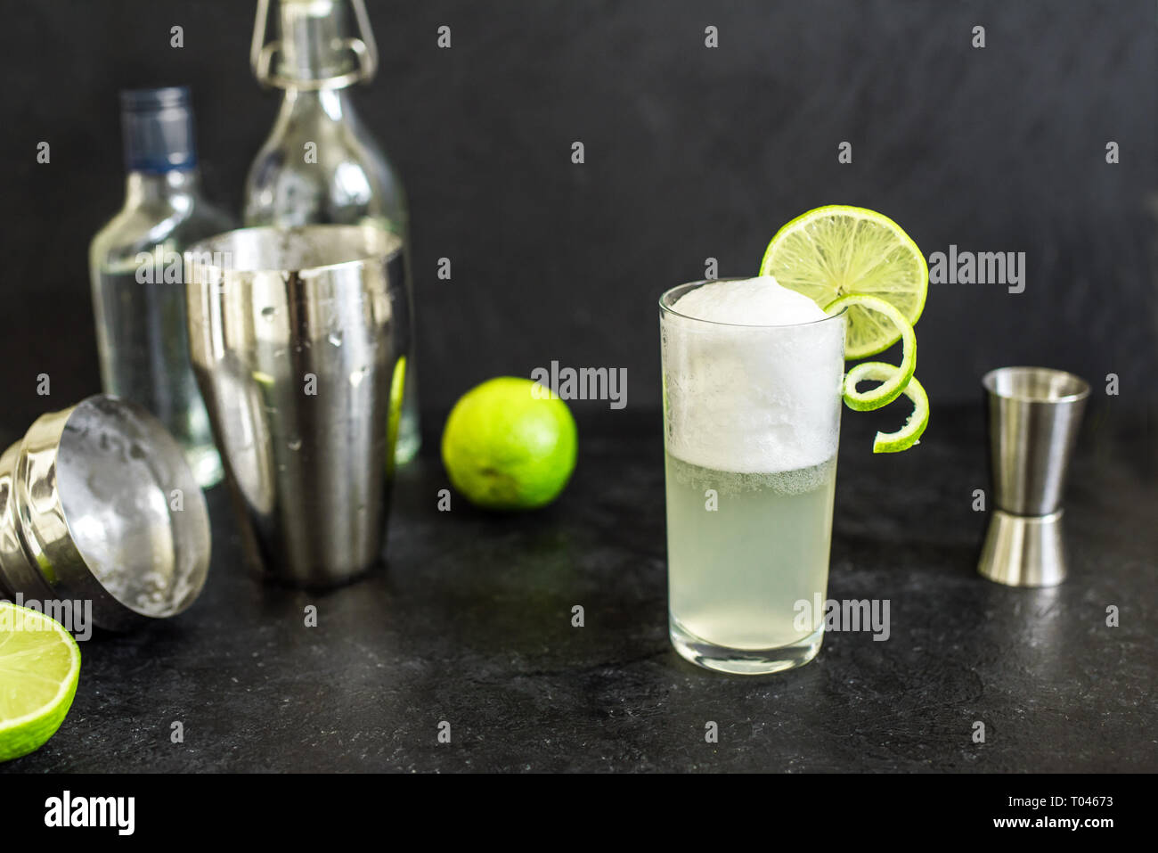 Egg Gin Fizz Cocktail with Lime Garnish. Making Gin Fizz Drink on black