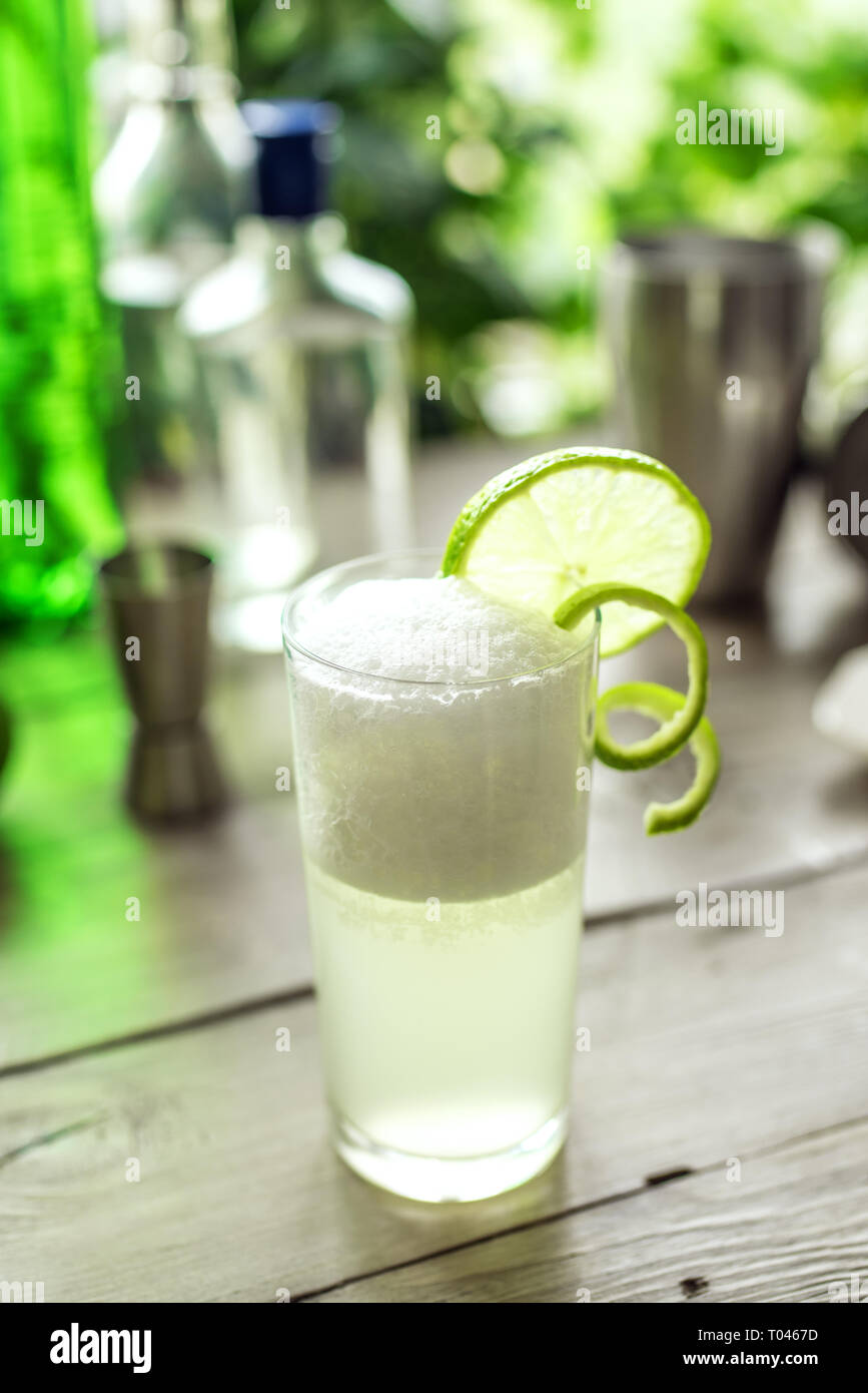 Egg Gin Fizz Cocktail with Lime Garnish. Making Gin Fizz Drink with