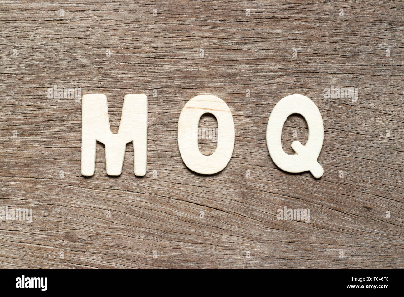 Alphabet letter in word MOQ (Abbreviation of Minimum Order Quantity) on wood background Stock