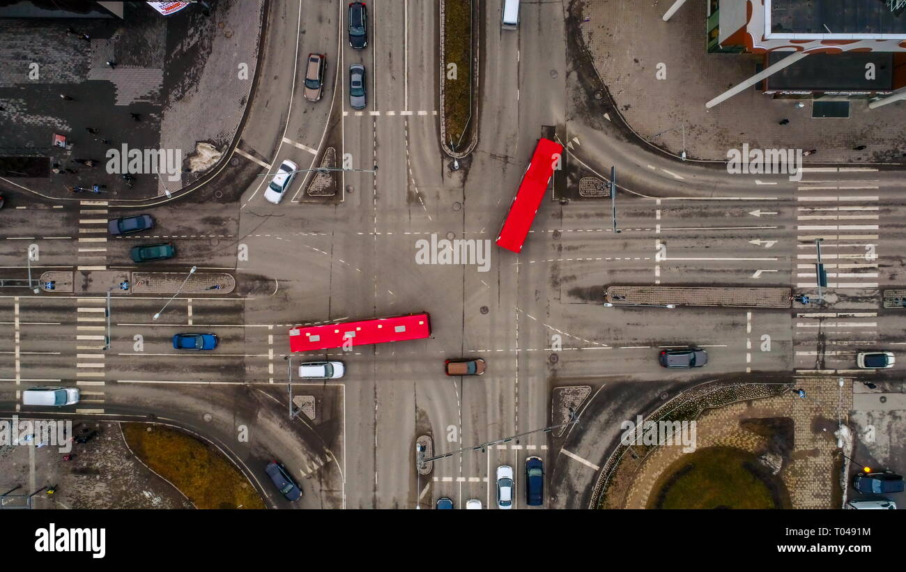 Different sizes of cars travelling on the road in Tartu Estonia crossing the intersection on a traffic signs in an aerial view Stock Photo