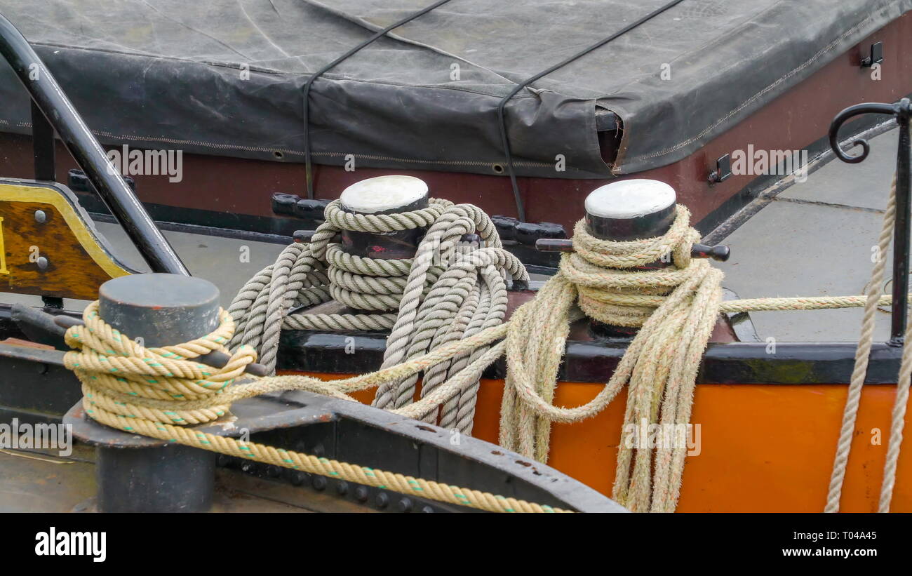 The ropes connecting the two sailbaots while docking on the river canal ...