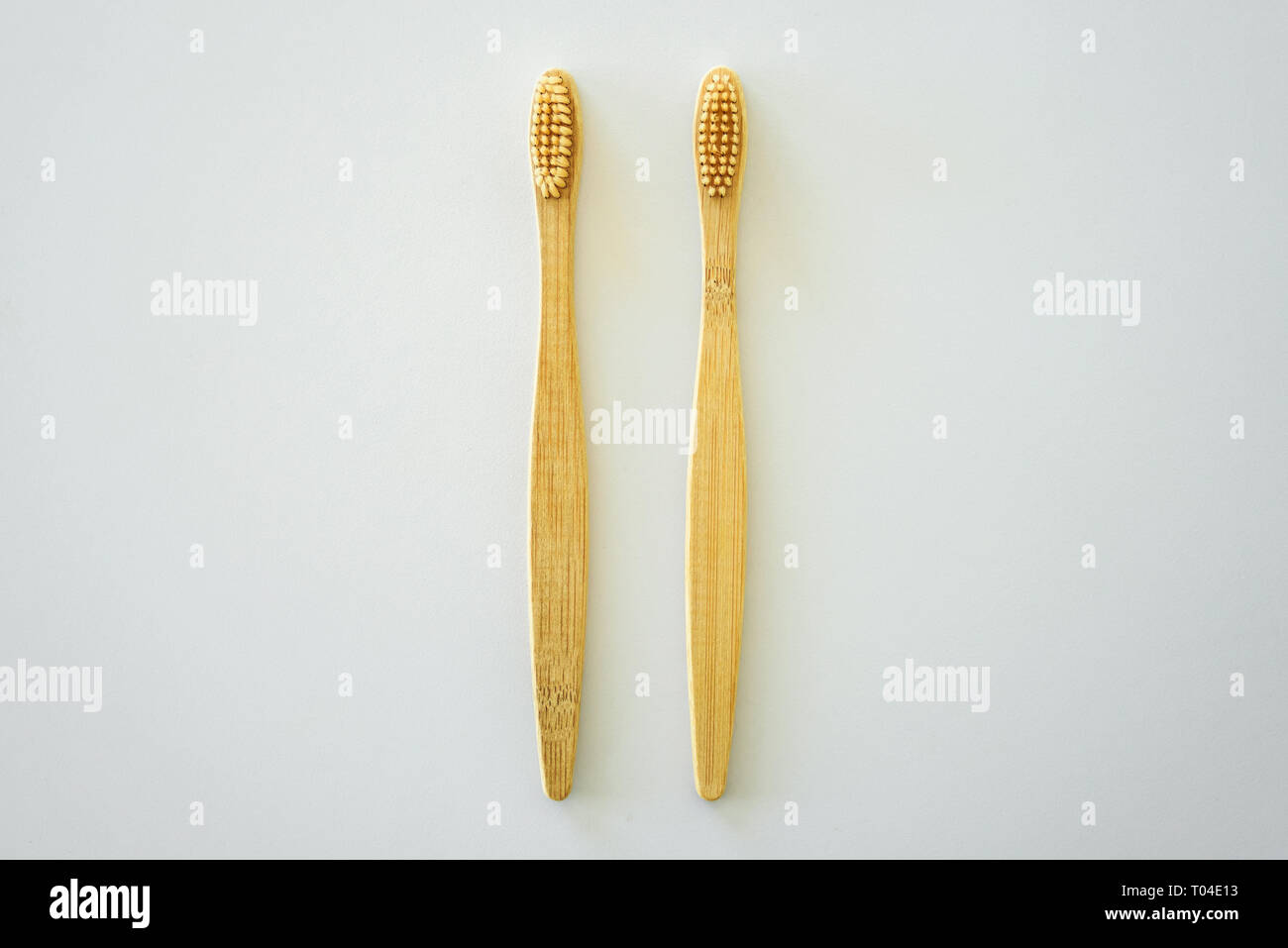 Two bamboo wooden toothbrushes on light grey background Stock Photo - Alamy