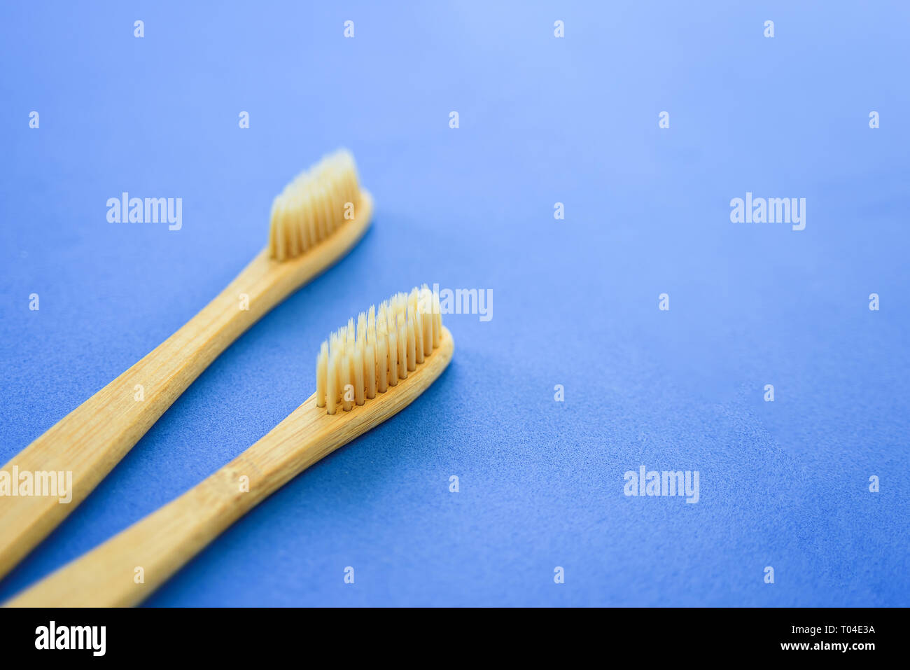 Two bamboo wooden toothbrushes on light grey background Stock Photo - Alamy