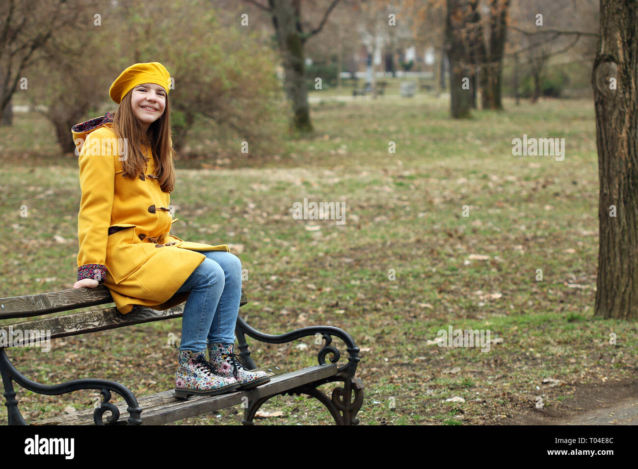 happy teenage girl is sitting on the bench in the park Stock Photo - Alamy