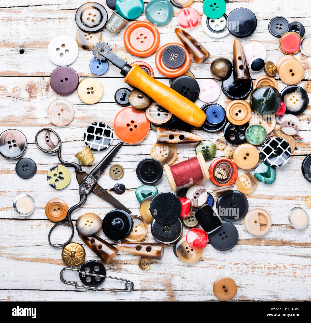 Spools of threads and buttons on wooden table.Scissor, sewing buttons