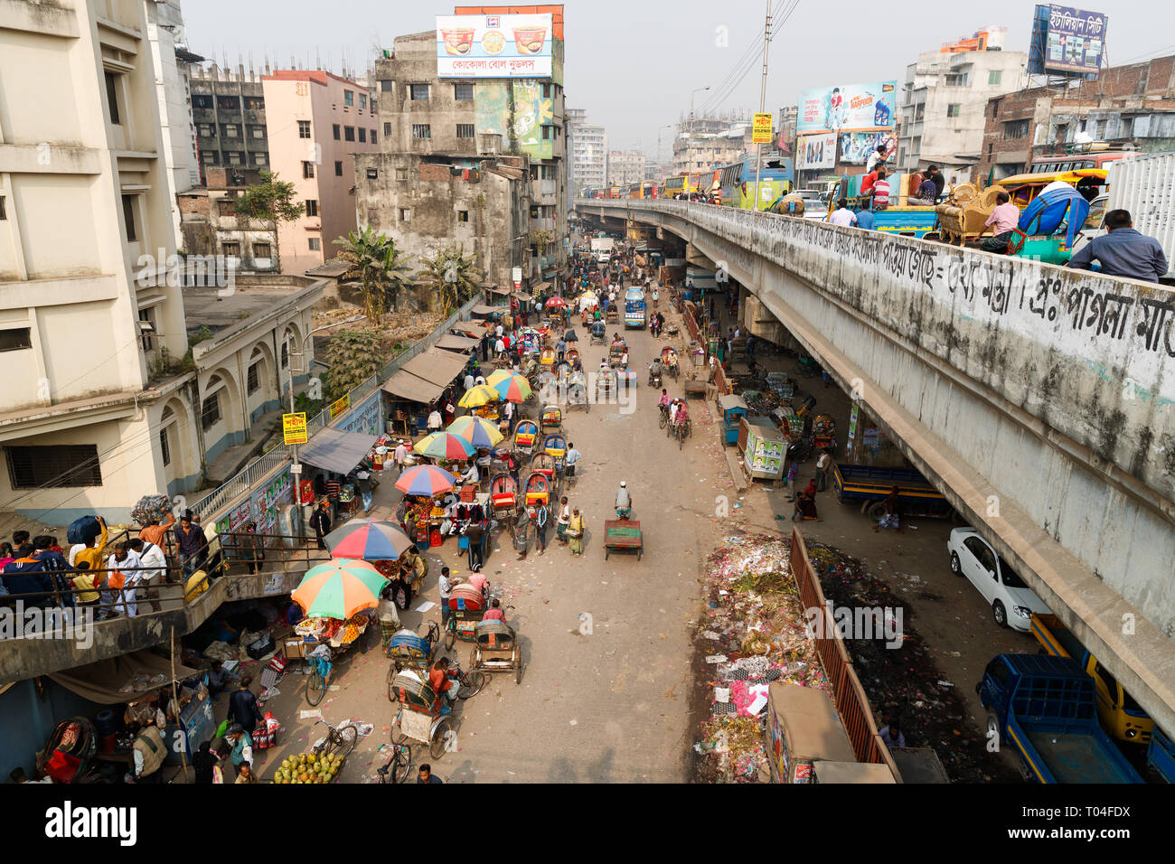 Busy traffic filling a street in central Dhaka. Cycle rickshaws, buses, people and cars compete for space on the crowded street. Stock Photo