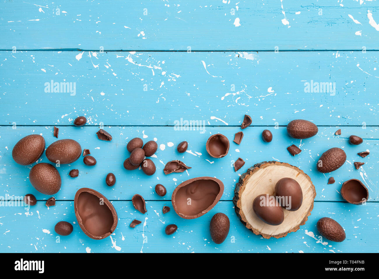 Delicious chocolate Easter bunny, eggs and sweets on rustic background Stock Photo