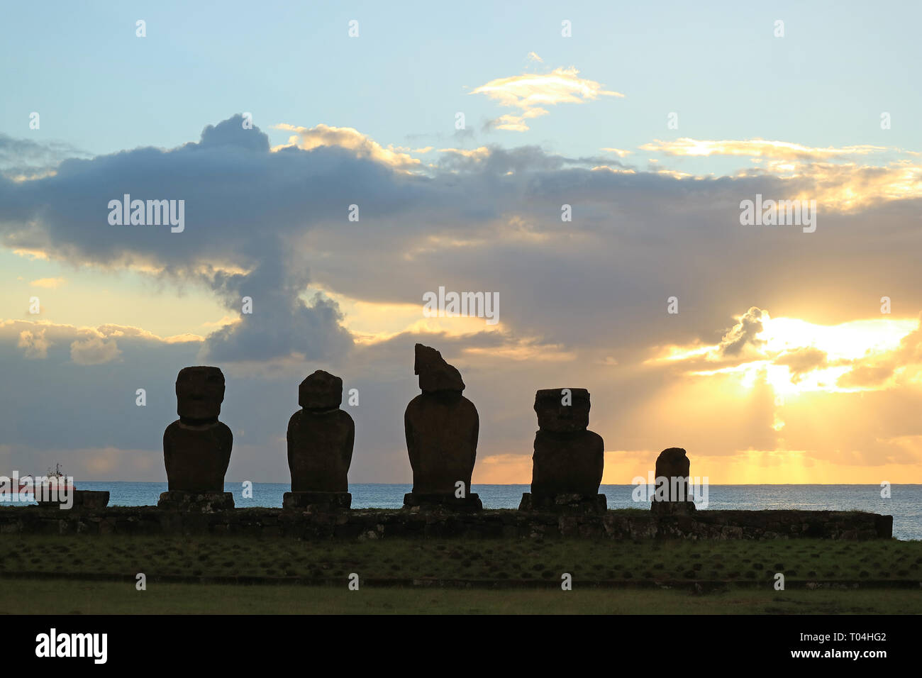 Silhouette of the Moais at Ahu Tahai Ceremonial Platform against Sunset over Pacific Ocean, Archaeological site on Easter Island, Chile Stock Photo