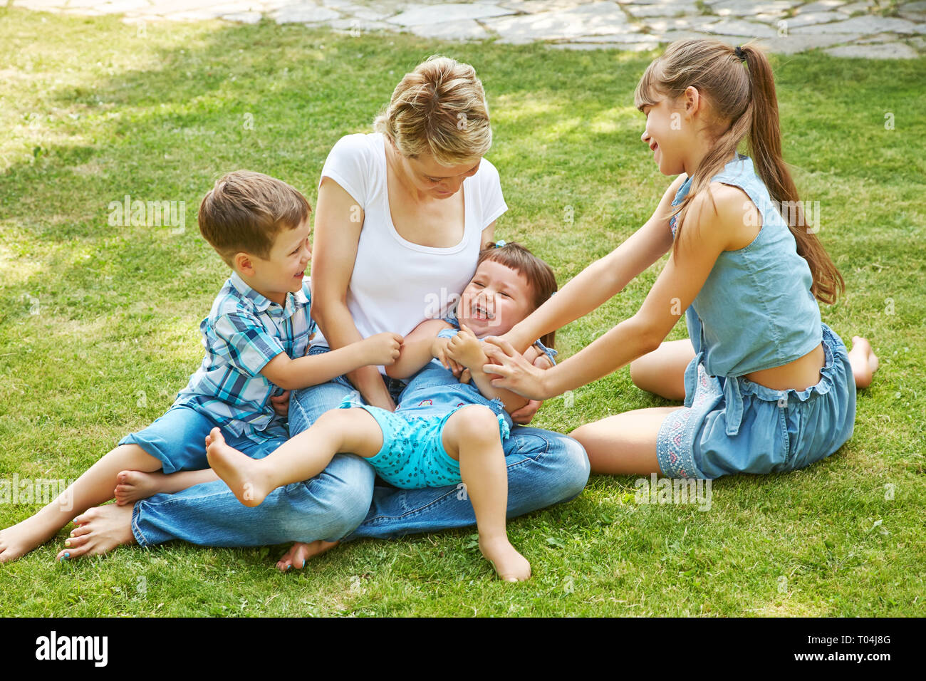 playful family outdoors. mom with children in the summer. Mother and kids Stock Photo