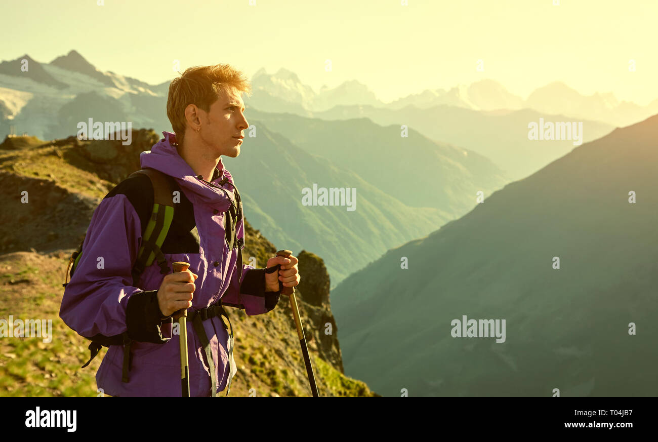 climber on trail in the mountains. a man with backpack in a hike Stock Photo