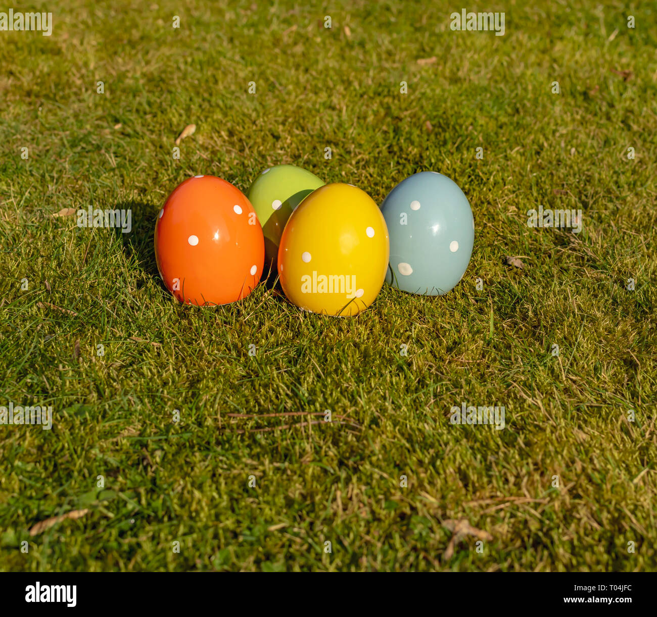 Colorful ceramic easter eggs lying on a meadow. Stock Photo