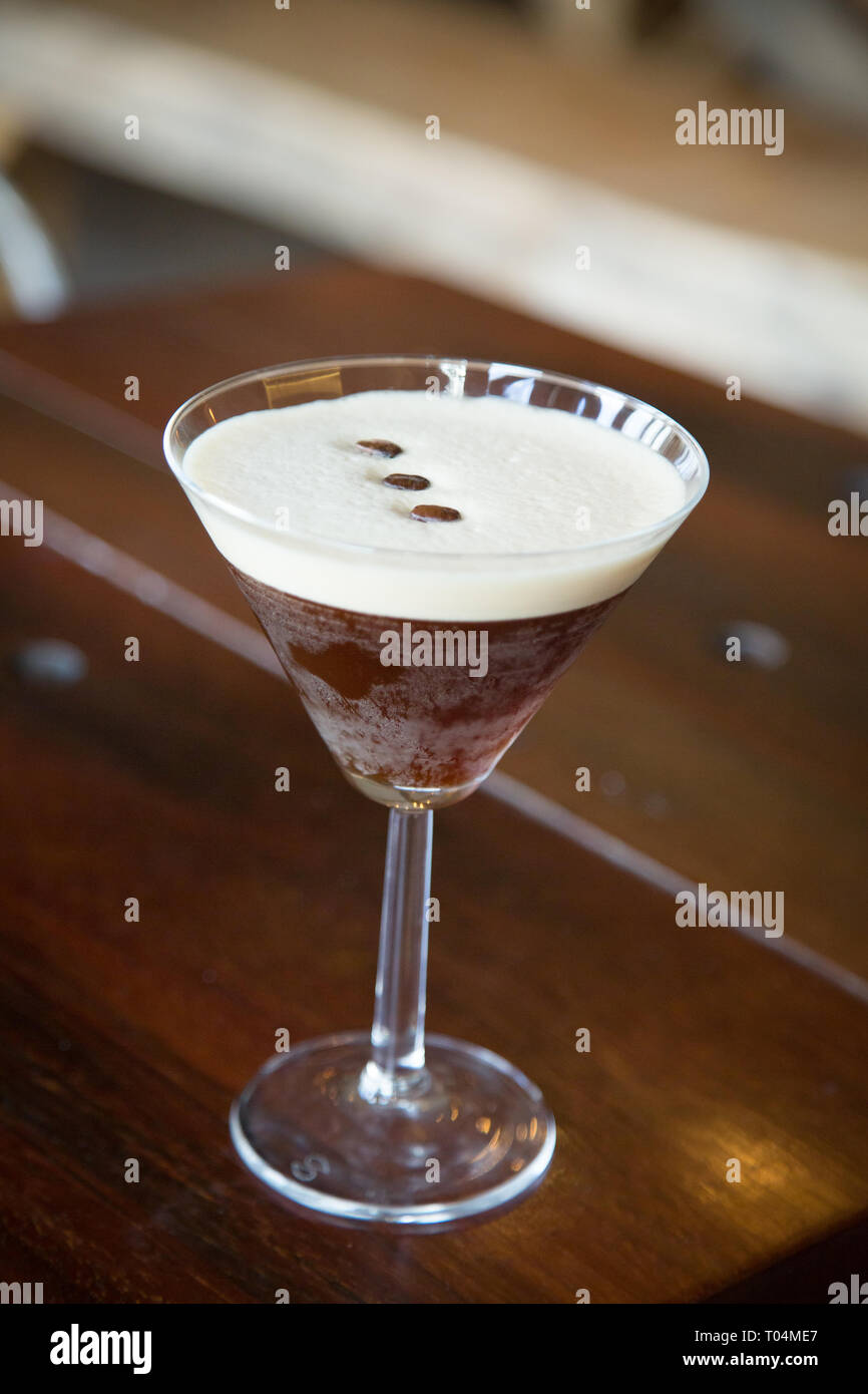 Icy espresso martini on bar with coffee bean garnish Stock Photo Alamy
